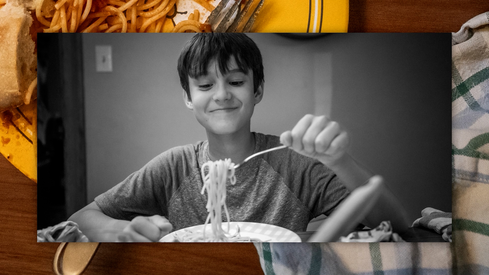 Black and white photo of a child eating spaghetti